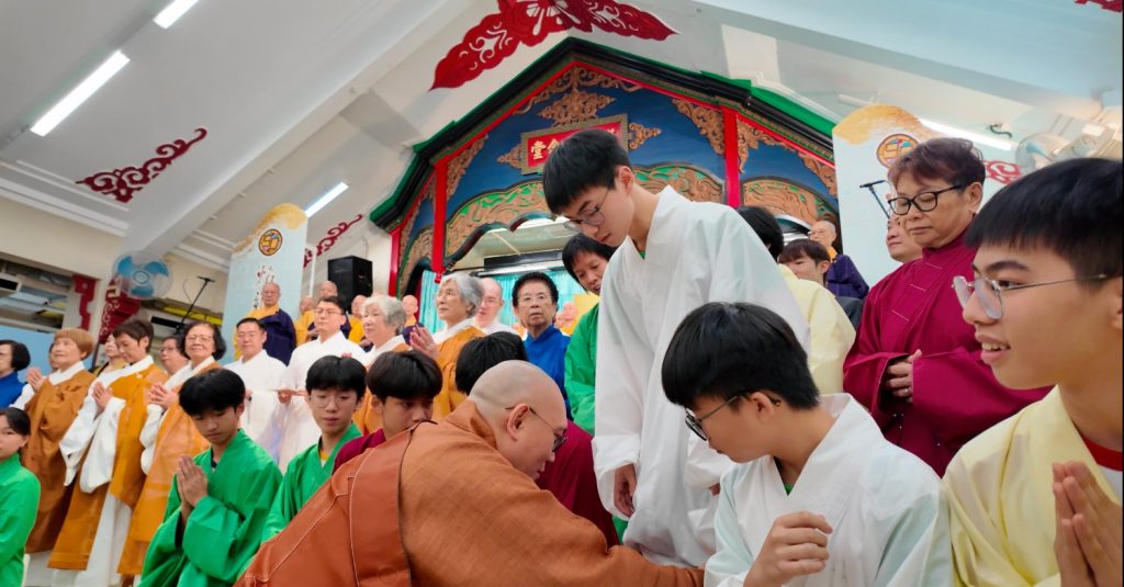 音聲佛事共賞會圓滿後，參與共賞會的寶覺小學學生一同合照，苑長為同學整理袍服。